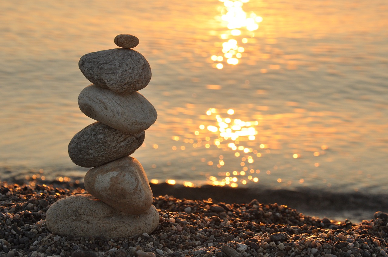 Caillou au bord de la mer au coucher de soleil, image symbolisant la définition de la sophrologie et la sérénité à Andernos-les-Bains
